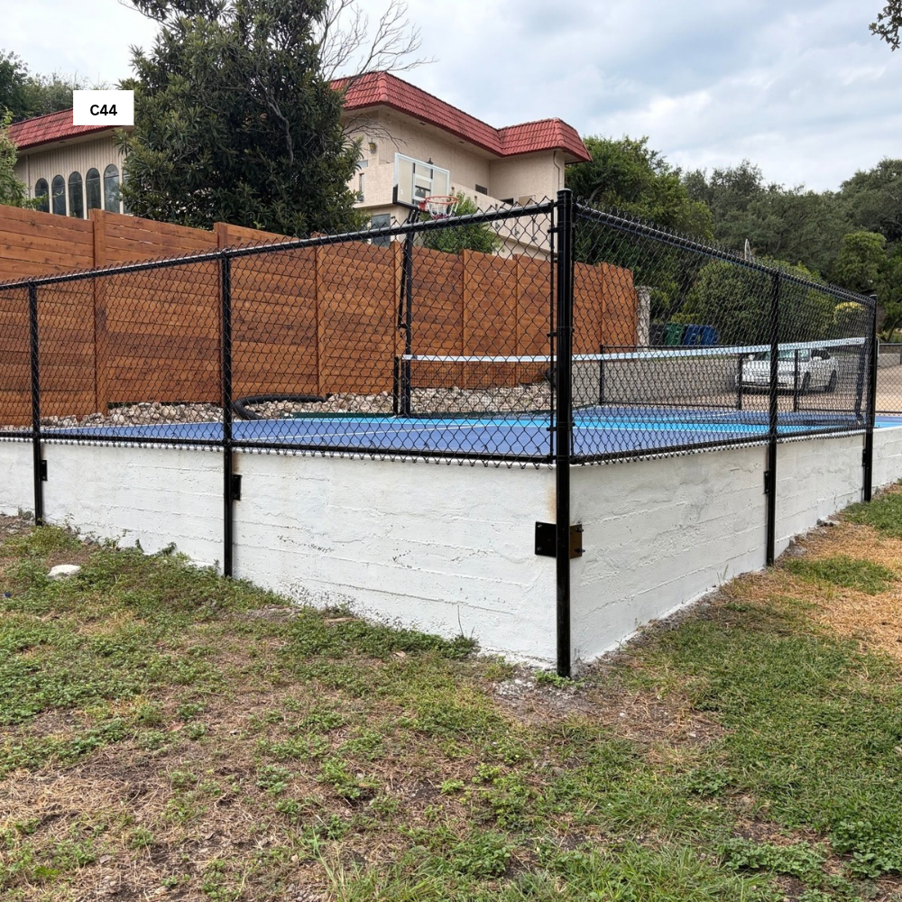 4’ tall Black Vinyl Chain Link mounted to elevated Concrete wall with top & Bottom rails for tennis court